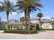 Clubhouse featuring a circular drive, manicured landscaping, and palm trees at 4116 Knollpoint Dr, Wesley Chapel, FL 33544