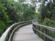 Scenic wooden boardwalk meanders through lush greenery, inviting residents to enjoy nature walks in the Seven Oaks community at 4116 Knollpoint Dr, Wesley Chapel, FL 33544