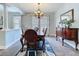 Dining room with hardwood floors, classic chandelier, and lots of light at 4116 Knollpoint Dr, Wesley Chapel, FL 33544