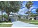 Charming two-story home with a manicured lawn, mature trees, and an attached two-car garage at 4116 Knollpoint Dr, Wesley Chapel, FL 33544