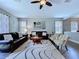 Comfortable living room featuring leather sofas, a ceiling fan, and stylish decor at 4116 Knollpoint Dr, Wesley Chapel, FL 33544
