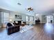 Spacious living room with hardwood floors, leather sofas, and an open floor plan at 4116 Knollpoint Dr, Wesley Chapel, FL 33544