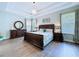 Spacious primary bedroom boasts tray ceilings and hardwood floors at 4116 Knollpoint Dr, Wesley Chapel, FL 33544
