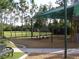 Community playground with swings, green space, and benches at 4116 Knollpoint Dr, Wesley Chapel, FL 33544