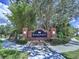 Landscaped brick sign for Knoll Pointe community with lush green trees and bushes at 4116 Knollpoint Dr, Wesley Chapel, FL 33544