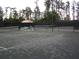 Community tennis court with bench and covered area with chairs and table at 4116 Knollpoint Dr, Wesley Chapel, FL 33544