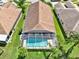 Aerial view of a home with a screened-in pool, surrounded by green lawns and mature trees at 4901 Windingbrook Trl, Wesley Chapel, FL 33544