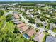 An aerial shot of a well-maintained community with manicured lawns, mature trees and a central lake at 4901 Windingbrook Trl, Wesley Chapel, FL 33544