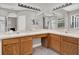 Bathroom featuring dual sinks, vanity lighting, and tile flooring at 4901 Windingbrook Trl, Wesley Chapel, FL 33544