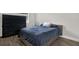 This bedroom features a queen size bed, a dark dresser, and wood-look floors at 4901 Windingbrook Trl, Wesley Chapel, FL 33544