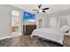 Bright bedroom featuring an ensuite bathroom, hard wood floors, and large TV at 4901 Windingbrook Trl, Wesley Chapel, FL 33544