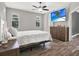 Bedroom with wood-look tile flooring, two windows, TV, dresser, and neutral color palette at 4901 Windingbrook Trl, Wesley Chapel, FL 33544