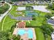 Aerial view of the neighborhood pool, clubhouse, playground, basketball and tennis courts and lake at 4901 Windingbrook Trl, Wesley Chapel, FL 33544