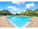 A tranquil community pool featuring clear blue water, brick pavers, and comfortable lounge chairs at 4901 Windingbrook Trl, Wesley Chapel, FL 33544