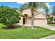 Inviting single-Gathering home featuring a well-kept lawn, mature trees, and an attached two-car garage at 4901 Windingbrook Trl, Wesley Chapel, FL 33544