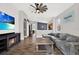 Spacious living room with fireplace, TV, wood-look tile flooring, and view to the kitchen at 4901 Windingbrook Trl, Wesley Chapel, FL 33544