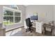 Functional home office featuring a large window, wood flooring and a work desk with a computer at 4901 Windingbrook Trl, Wesley Chapel, FL 33544