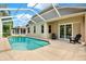 Beautiful screened-in pool area with a covered lanai and chairs for relaxing and lounging at 4901 Windingbrook Trl, Wesley Chapel, FL 33544