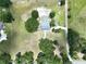 Aerial view of a gray roofed home surrounded by green lawns and mature trees at 5007 Booth Rd, Plant City, FL 33565