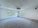 Spacious carpeted bedroom with two windows and a ceiling fan for comfort at 5007 Booth Rd, Plant City, FL 33565
