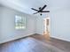 Light-filled bedroom boasts sleek ceiling fan, wood-look flooring, and neutral decor at 5007 Booth Rd, Plant City, FL 33565
