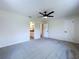 Spacious bedroom featuring soft gray carpet, a ceiling fan, and an ensuite bathroom entrance at 5007 Booth Rd, Plant City, FL 33565