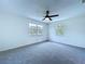 Spacious bedroom featuring plush carpeting, a ceiling fan, and bright natural light from two windows at 5007 Booth Rd, Plant City, FL 33565