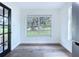 Dining area with hardwood floors, a window overlooking the backyard, and a black frame glass door at 5007 Booth Rd, Plant City, FL 33565