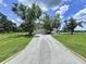 Long driveway leading to a beautiful home with lush landscaping and mature trees at 5007 Booth Rd, Plant City, FL 33565