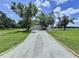 Long driveway leading to a beautiful home with lush landscaping and mature trees at 5007 Booth Rd, Plant City, FL 33565