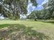 View of a two-story home across a large green lawn with mature trees at 5007 Booth Rd, Plant City, FL 33565