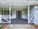 Charming covered front porch with gray exterior and decorative white railing, offering a warm welcome at 5007 Booth Rd, Plant City, FL 33565