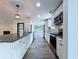 Kitchen featuring granite countertops, stainless steel appliances, white cabinets, and modern pendant lighting at 5007 Booth Rd, Plant City, FL 33565