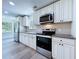 Kitchen features white cabinets, granite countertops, and stainless steel appliances at 5007 Booth Rd, Plant City, FL 33565