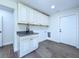 Bright laundry room boasts ample cabinet space and sleek vinyl flooring with sink at 5007 Booth Rd, Plant City, FL 33565