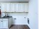 Bright laundry room featuring custom cabinets, granite counters, and wood-look tile flooring at 5007 Booth Rd, Plant City, FL 33565