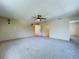 Spacious living room with neutral carpet, ceiling fan, and stylish wall sconces at 5007 Booth Rd, Plant City, FL 33565
