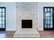 Living room showcasing stone fireplace, hardwood floors and French doors with ample natural light at 5007 Booth Rd, Plant City, FL 33565