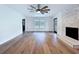 Spacious living room featuring hardwood floors, stone fireplace, large window, ceiling fan, and black glass doors at 5007 Booth Rd, Plant City, FL 33565