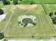 Aerial view of a pond surrounded by green grass and a white perimeter fence at 5007 Booth Rd, Plant City, FL 33565