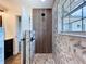 Luxurious walk-in shower features sleek wood-look tile, dual shower heads, and designer accent wall at 5007 Booth Rd, Plant City, FL 33565