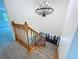 Carpeted staircase with wooden railing and modern light fixture at 5007 Booth Rd, Plant City, FL 33565