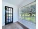 Bright sun room with hardwood floors, large windows offering scenic views, and a glass-paneled door, creating a cozy space at 5007 Booth Rd, Plant City, FL 33565