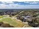Aerial view showcasing a golf course, clubhouse, and residential area nestled within a vibrant community at 5315 Cedarshake Ln, Valrico, FL 33596