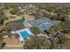 Panoramic aerial view featuring a community pool, tennis courts, and clubhouse surrounded by lush greenery at 5315 Cedarshake Ln, Valrico, FL 33596
