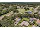 Scenic aerial view featuring a home with a screened pool, surrounded by mature trees and golf course community at 5315 Cedarshake Ln, Valrico, FL 33596