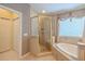 Bathroom featuring a soaking tub, glass shower, and neutral wall color at 5315 Cedarshake Ln, Valrico, FL 33596