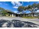 Exterior view of the clubhouse with porte-cochere, beautiful landscaping, and parking at 5315 Cedarshake Ln, Valrico, FL 33596