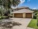 Attractive home featuring a wide driveway leading to a three-car garage and lush front yard at 5315 Cedarshake Ln, Valrico, FL 33596