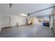 Spacious garage featuring epoxy flooring, utility sink, water heater, and an overhead door with automatic opener at 5315 Cedarshake Ln, Valrico, FL 33596